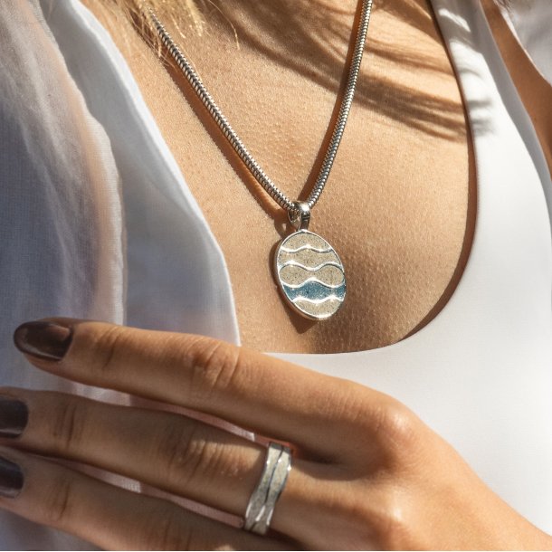 Vedhng i slv med hvid og bl strand sand 